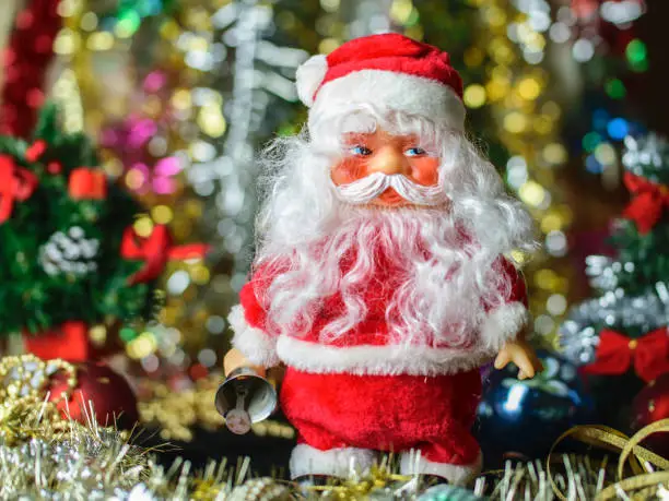 Toy Santaclaus against the background of bright sparkling festive tinsel
