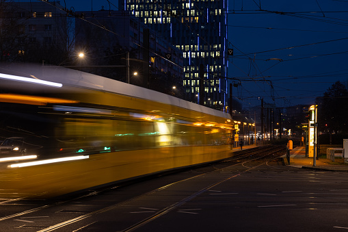 Night time photograph of a blurred tram moving through the rails of Berlin