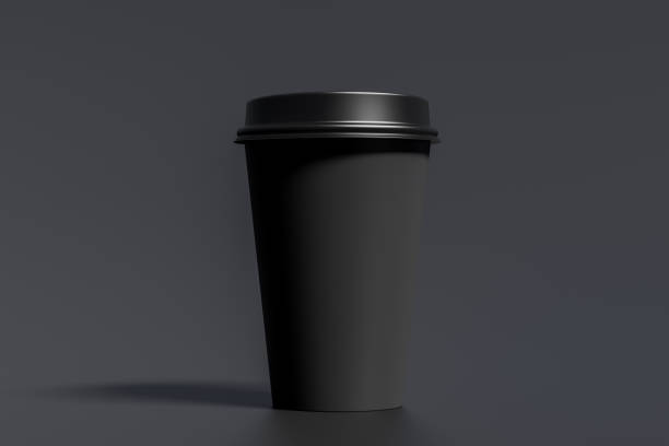 istock Black take away coffee paper cup mock up with black lid on black background. 1291078773