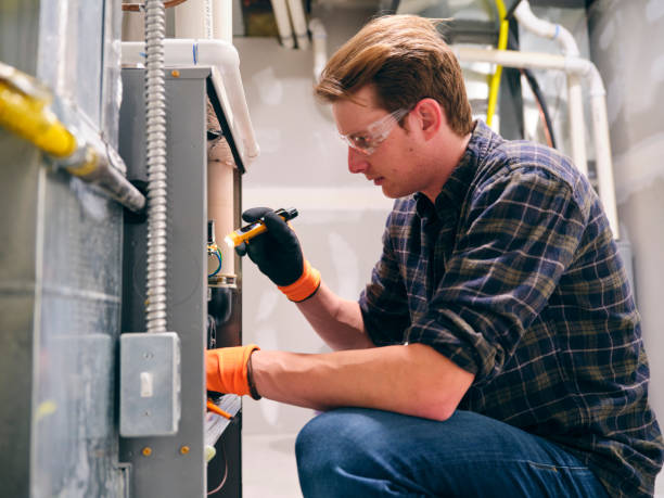 Home Repairman Working on a Furnace stock photo
