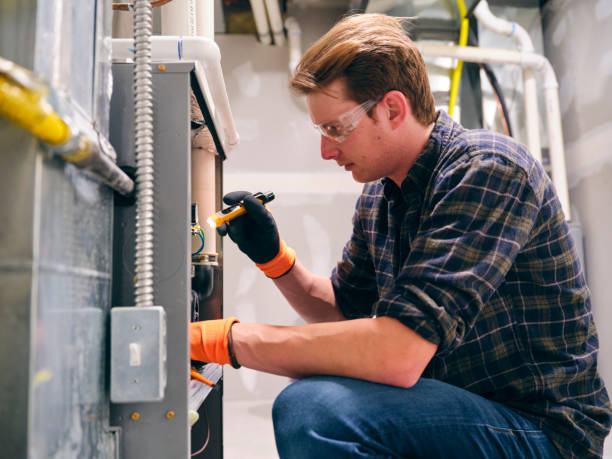 home repairman working on a furnace - fix up imagens e fotografias de stock