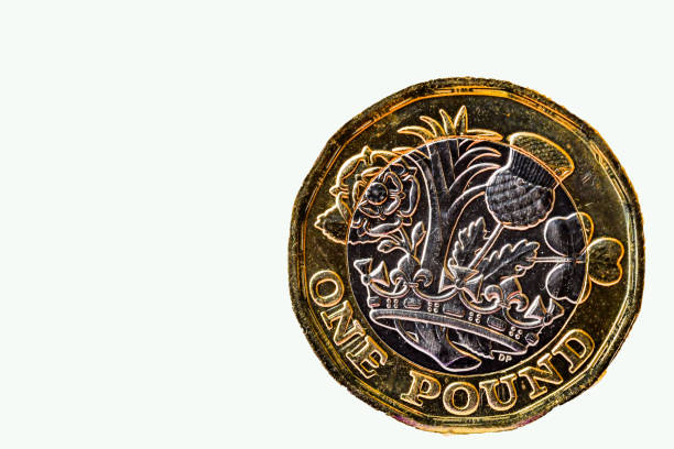 istock British one pound coin standing on its edge on a plain background 1291081115