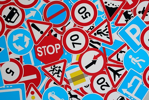 Many american and european traffic signs mixed together. Road safety concept