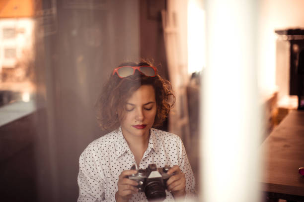 Retro styled female photographer sitting with her camera