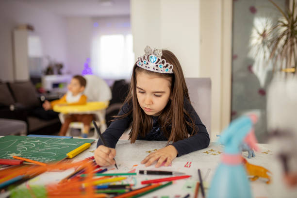 cute little girl coloring at home - child thinking writing little girls imagens e fotografias de stock