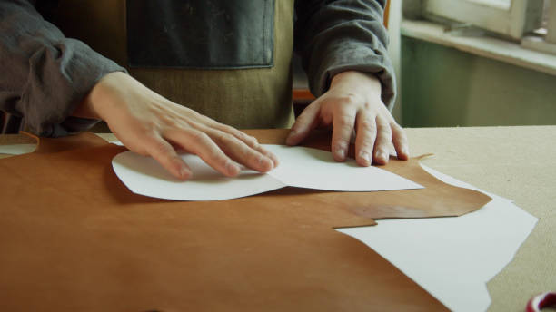 istock Hands of a master tailor close-up without a face. Pattern for making women's bags made of genuine leather 1291084849