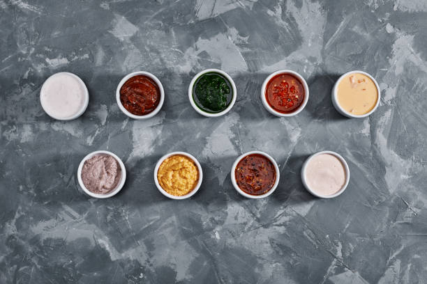 Different tasty sauces in bowls, various sauces on gray stone background, top view Different tasty sauces in bowls, various sauces on gray stone background, top view. marinated photos stock pictures, royalty-free photos & images