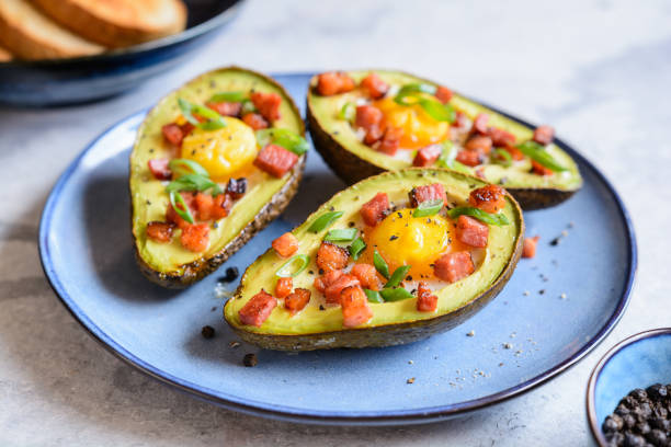 Avocado egg boats with bacon and green onion Roasted avocado egg boats with bacon and green onion cooked bacon slice stock pictures, royalty-free photos & images