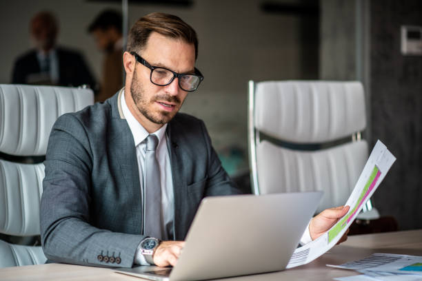 istock Junior businessman sitting in conference room, preparing presentation. 1291090757