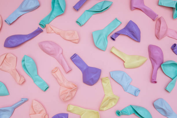 istock Colorful blown out balloons on pink background 1291092526