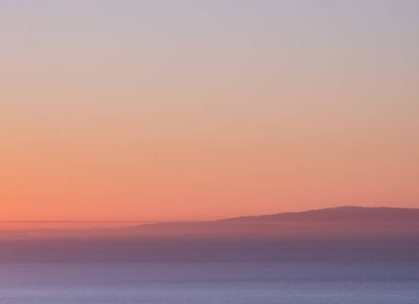 An almost abstract pink gradient sunset over the ocean.