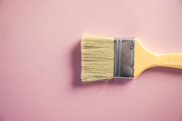 istock paint brush and pastel pink background 1291094086