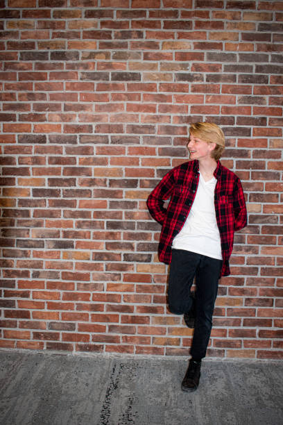 istock Young teenager leaning against a brick wall 1291094956