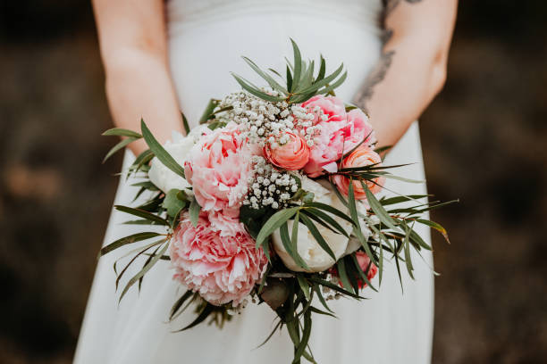 白いドレスを着た花嫁がピンクと緑の花の結婚式の花束を飾っています。クローズアップ。結婚式の日。 - bride caucasian wedding ceremony close up ストックフォトと画像