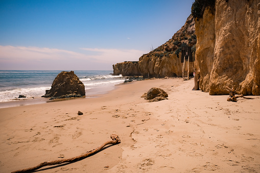 Down on Malibu's El Matador Beach and a beautiful sunny day. The high coastal cliffs to the right, the waves and boulders to the left, and sandy footprints on the beach dead ahead.