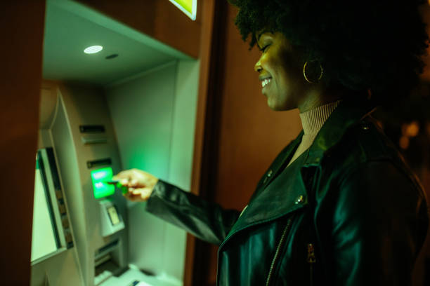 istock Afro woman making a transaction at an ATM 1291099651