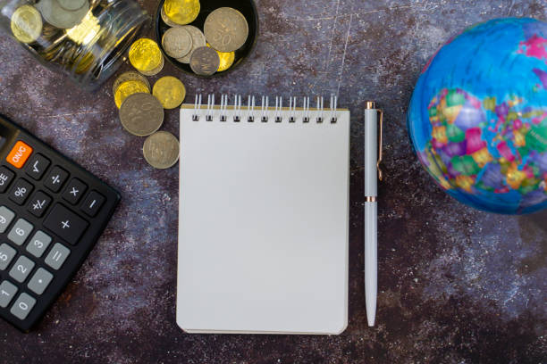 istock Noted Pad, Coins, Calculator and World Map Globe. 1291100165