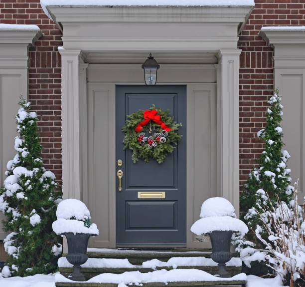 눈 덮인 계단소나무 콘 크리스마스 화환이 있는 현관 - wreath christmas door snow 뉴스 사진 이미지