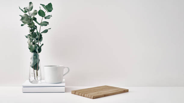 istock A mug, a stack of books, a wooden board and a transparent vase with eucalyptus branches. Eco-friendly materials in interior decor, minimalism. Copy space, mock up 1291101410