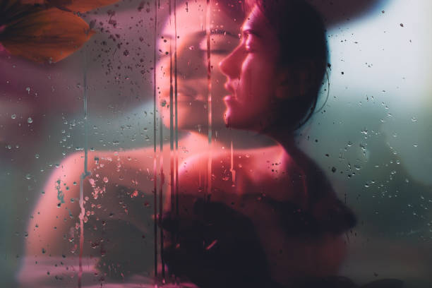 nature portrait woman silhouette glass rain drops Nature portrait. Pure soul. Sensual woman face blur silhouette in neon red bokeh light behind steamed glass with rain drops double exposure effect. Beauty wellness. Dreamlike freshness. sensuality stock pictures, royalty-free photos & images