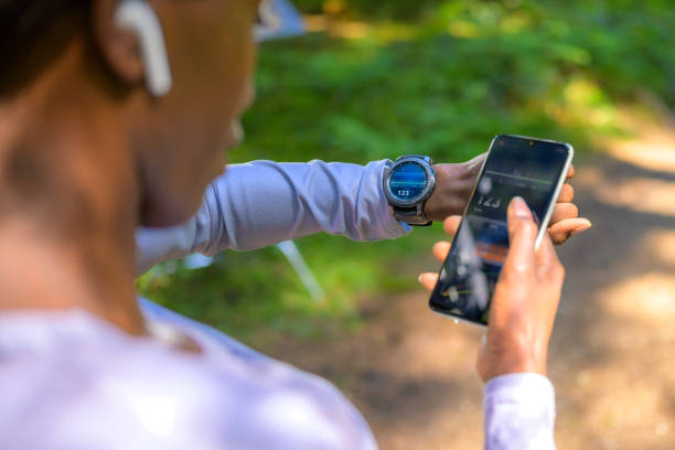 vista sobre el hombro en la mujer usando el software de seguimiento - ordenador para utilizar como accesorio fotografías e imágenes de stock