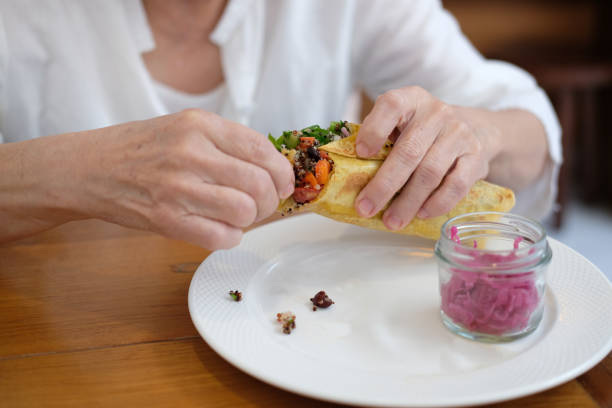 istock hand holding vegan wrap with quinoa, black bean, mango, cashew nut, bell pepper 1291101749