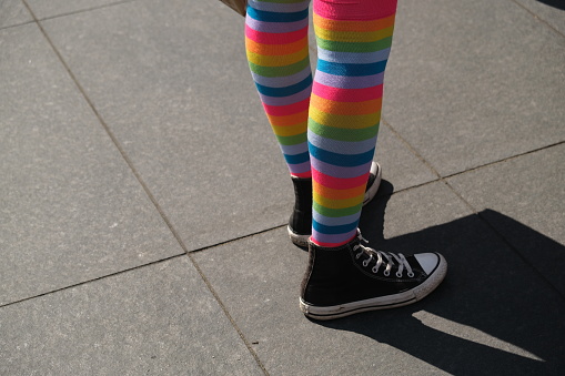Closeup of female legs wearing rainbow socks and sneakers -Pride in Budapest