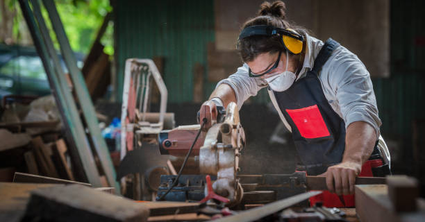 istock caucasian carpenter working in wood workshop cutting wood piece with circular saw on work table in wood workshop. concept of carpenter working in workshop 1291107769