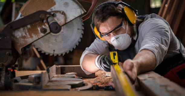 istock caucasian carpenter working in wood workshop meaturing woodwork with tape measure on work table. concept of carpenter work in wood workshop 1291107774