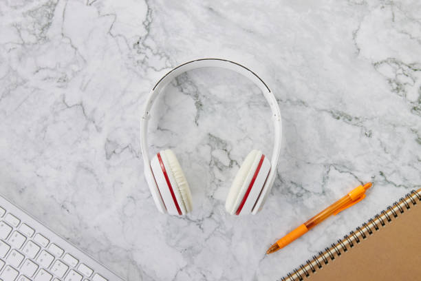 istock Headphone and Office Supplies on Marble Office Desk or Table Background 1291122828