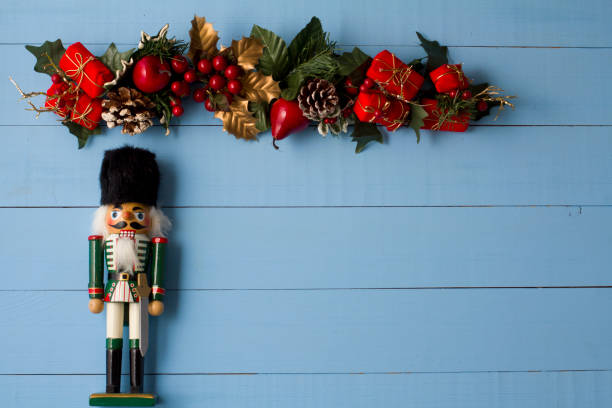 istock Interesting beautiful Christmas ornaments decorations with nutcracker soldier on blue colored wooden surface texture with copy space. 1291123782