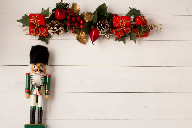 istock Interesting beautiful Christmas ornaments decorations with nutcracker soldier on white colored wooden surface texture with copy space. 1291123860
