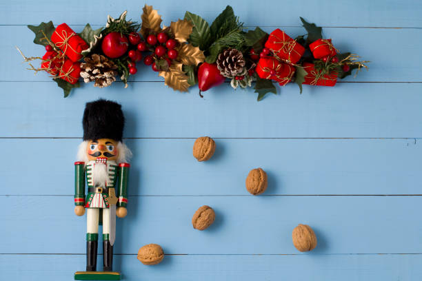 istock Interesting beautiful Christmas ornaments decorations with nutcracker soldier on blue colored wooden surface texture with copy space. 1291126192