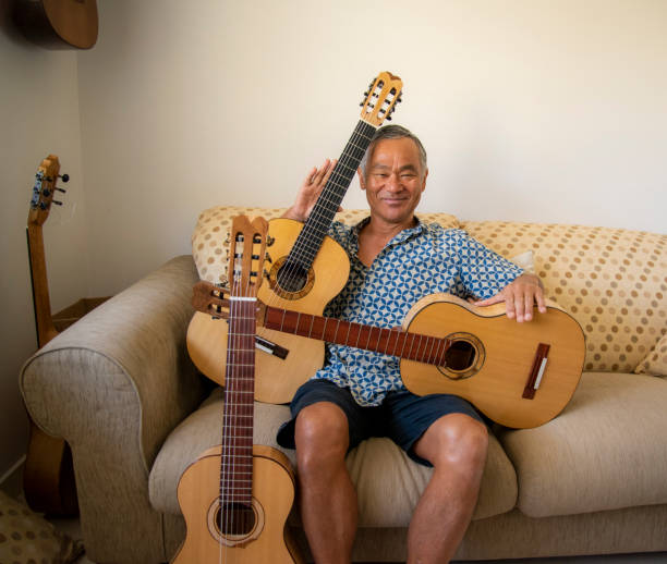 istock Man of Japanese origin enjoys sorting through the guitars he has made. 1291127273