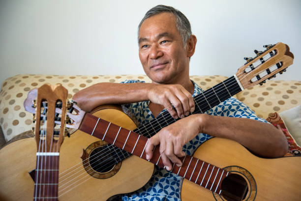 istock Man of Japanese origin enjoys sorting through the guitars he has made. 1291127367