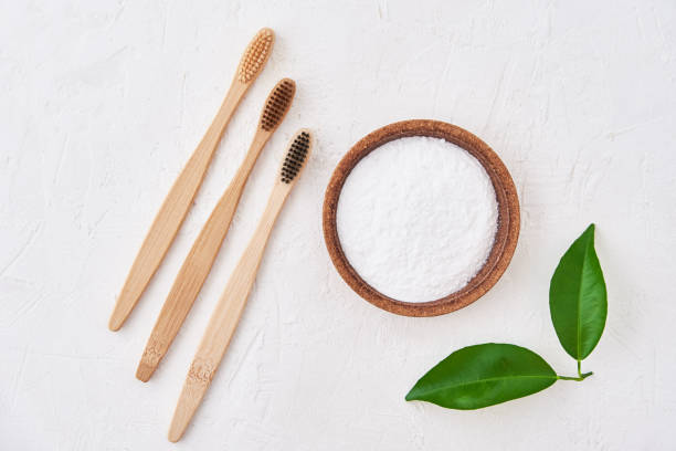 istock Three wooden bamboo toothbrushes and baking soda on white background, top view. Eco friendly toothbrushes, zero waste concept 1291127383
