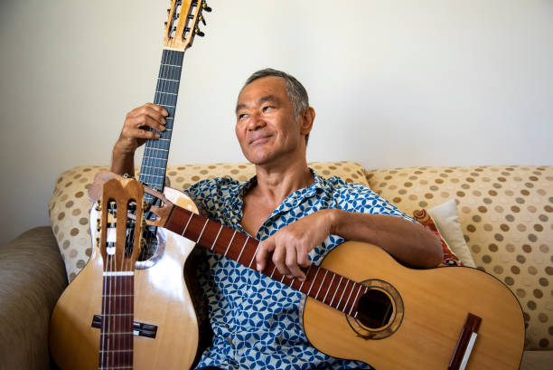 istock Man of Japanese origin enjoys sorting through the guitars he has made. 1291127384