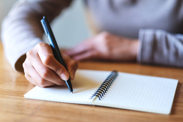 istock a woman writing on a blank notebook on the table 1291127927