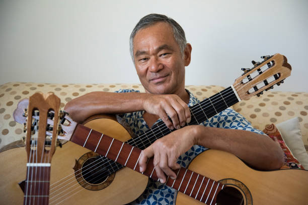 istock Man of Japanese origin enjoys sorting through the guitars he has made. 1291127977