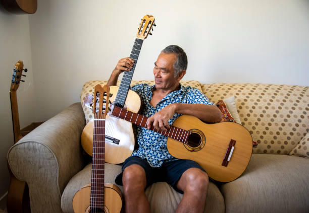 istock Man of Japanese origin enjoys sorting through the guitars he has made. 1291128063