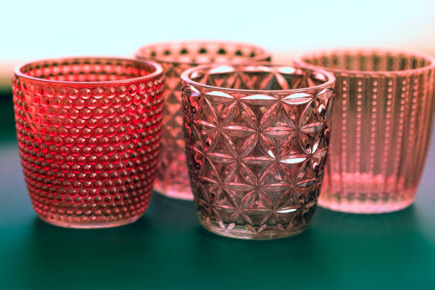 Glass candle cups stacked on a green background