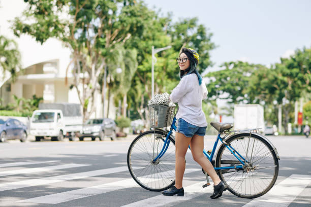 istock Woman with bicycle crossing road 1291131789