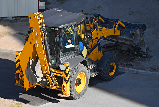 Contemporary yellow bulldozer on road construction site