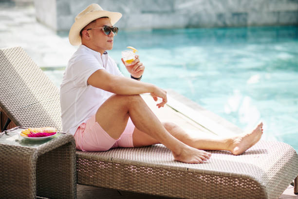 istock Stylish man resting by swimming pool 1291137522