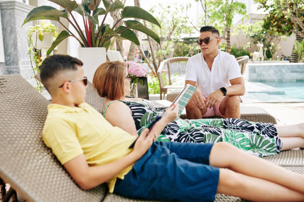 istock Family resting by swimming pool 1291137523