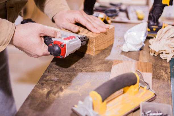 istock The master works in a studio and drill a hole in a wooden board. 1291140798
