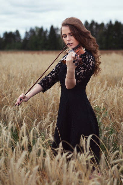 istock sad young woman playing violin romantic work in nature 1291141001