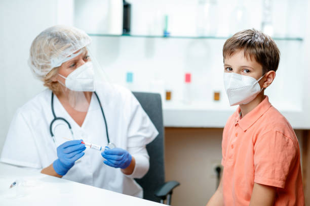 istock Boy with protective face mask waiting for PCR test in doctor's office and looking at camera 1291142109
