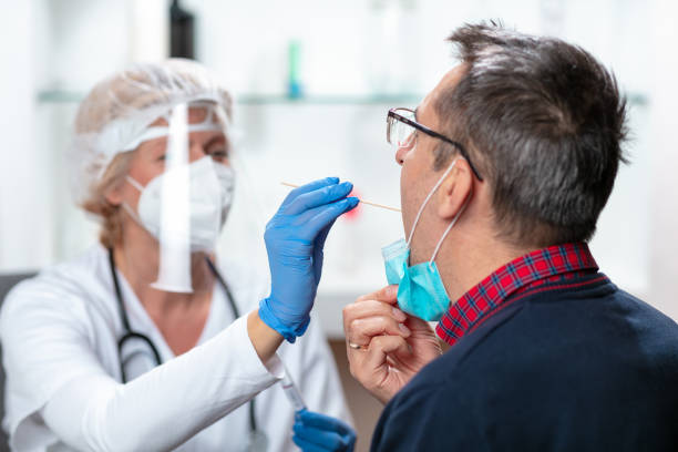istock Taking swab sample with long stick from patient's mouth 1291142133