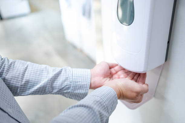 automatic alcohol dispenser in office building - hand sanitizer liquid soap hygiene healthy lifestyle imagens e fotografias de stock